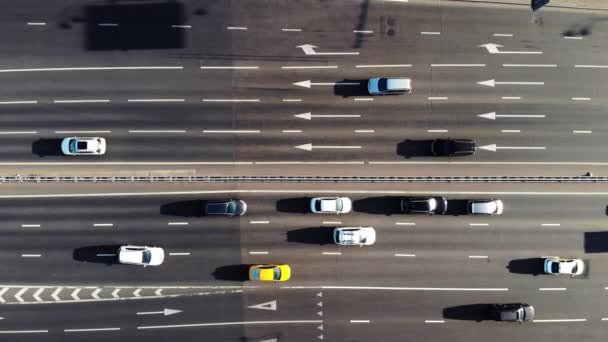 Auta vozí podél šedé široké asfaltové silnice s bílými značkami — Stock video