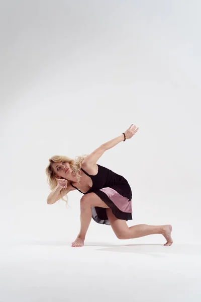 Bild av långhårig blondin ser till sidan med utsträckt hand Dans i studion — Stockfoto