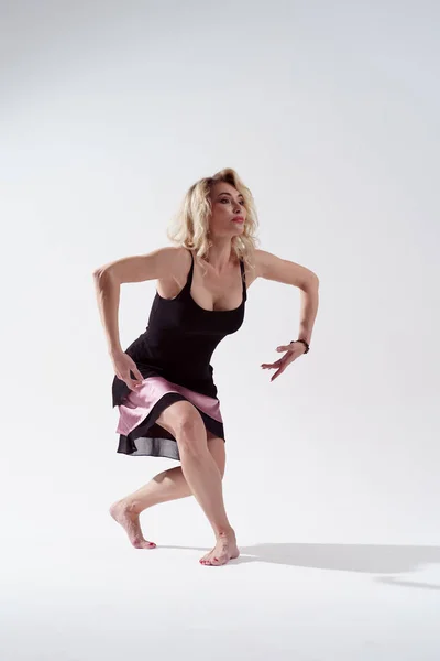 Zdjęcie młodej długowłosy blond kobieta patrząc na bok zaangażowany w taniec w Studio — Zdjęcie stockowe