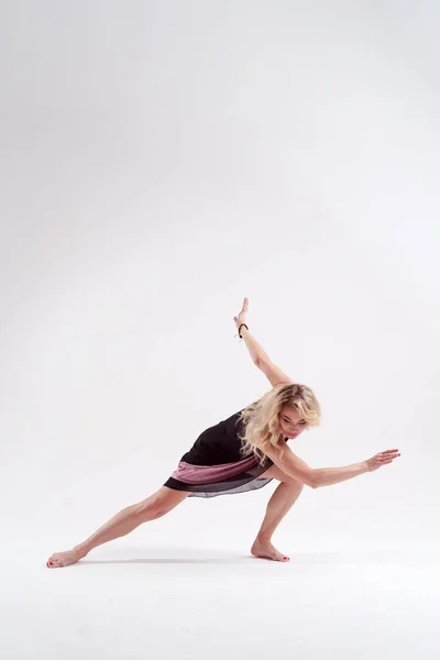 Wizerunek tańca młoda długowłosy kobieta Blondynka patrząc w czarnej sukni w Studio na białym tle — Zdjęcie stockowe