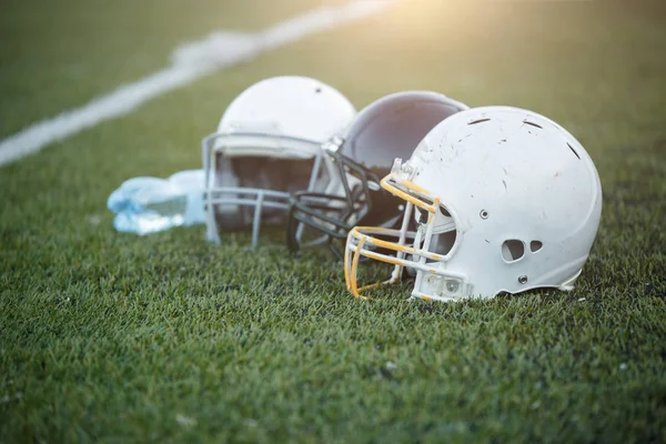 Photo of three football helmets on stadium