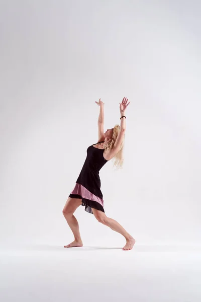 Zdjęcie z boku tańca Kręcone blond z ramionami podniesione i patrząc w Studio — Zdjęcie stockowe