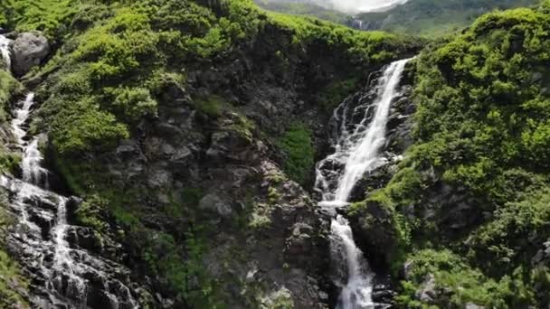 Adembenemende watervallen tussen grote rotsen met groene bomen — Stockvideo
