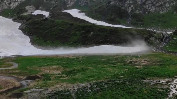 Vallée de montagne verdoyante avec neige parmi les hautes roches grises — Video