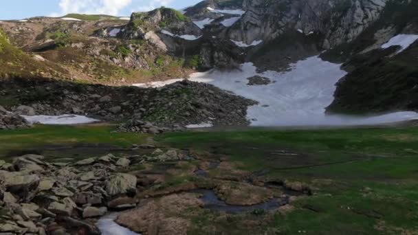 Adembenemende grote grijze bergen met sneeuw en groene vallei — Stockvideo