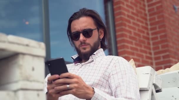 Tipos hipster con estilo en el teléfono inteligente y cambia las emociones — Vídeos de Stock