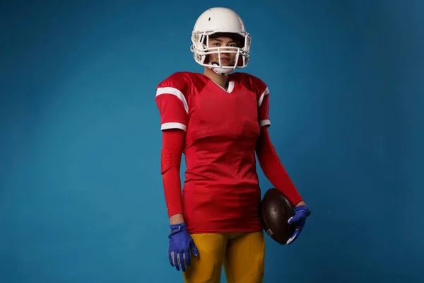 Imagem de jogador de futebol americano mulher em capacete branco, sportswear e bola em sua mão — Fotografia de Stock