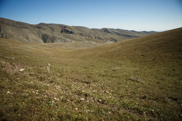 Bild eines Hügels mit grüner Vegetation, blauer, klarer Himmel — Stockfoto