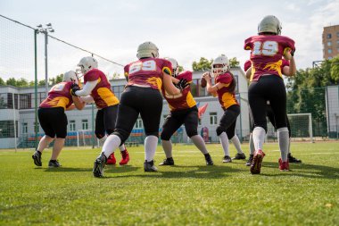 Yeşil çimüzerinde Amerikan futbolu oynayan sportif kadınların tam uzunlukta fotoğrafı