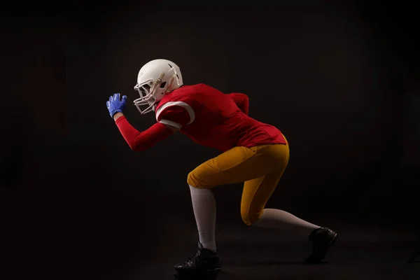 Foto de cuerpo entero del lado de la futbolista americana corriendo en el casco en el estudio — Foto de Stock