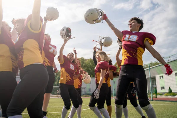 Foto da equipe de rugby mulher com as mãos levantadas olhando para a câmera — Fotografia de Stock