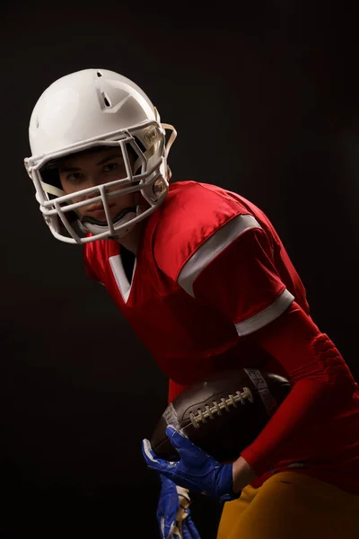 Foto einer Rugbyspielerin, die auf leerem schwarzen Hintergrund in die Kamera schaut — Stockfoto