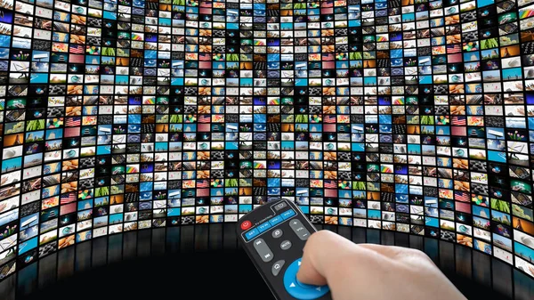 Imagen de pantalla grande con muchos canales, manos del hombre con control remoto . — Foto de Stock