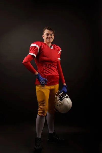 Obrázek šťastné americké brunetní fotbalové hráčka s přilbou v ruce — Stock fotografie