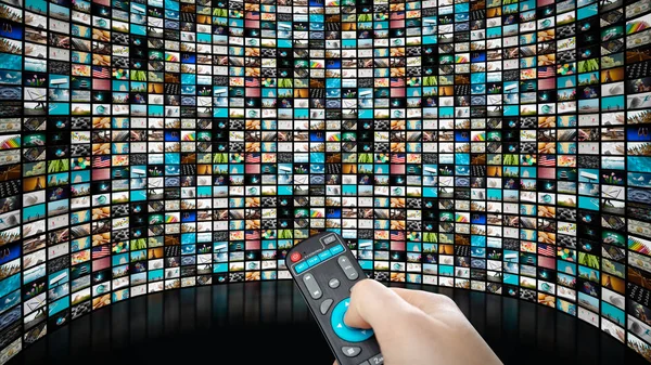 Image of big screen with many channels, hands of man with remote control . — Stock Photo, Image