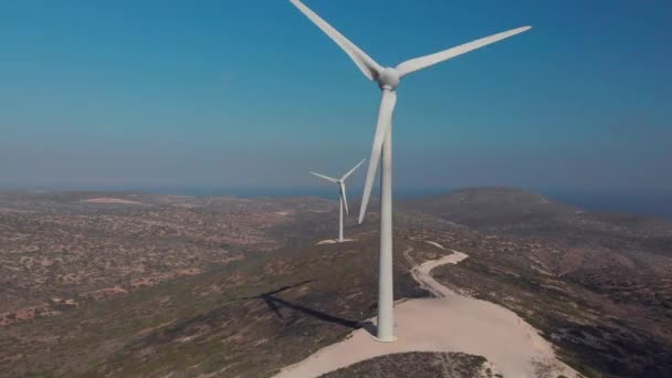 Cerrar modernas cuchillas de molino de viento rotan bajo el cielo azul claro — Vídeo de stock