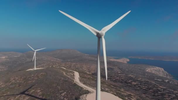 Modern white wind generators work on hilly coastline — Stock Video