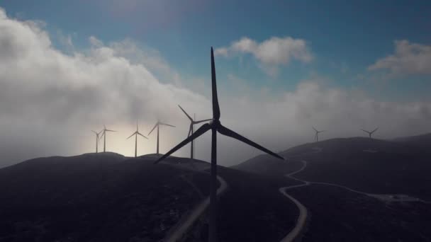 Molinos de viento en tierras altas bajo nubes que ocultan el sol — Vídeo de stock