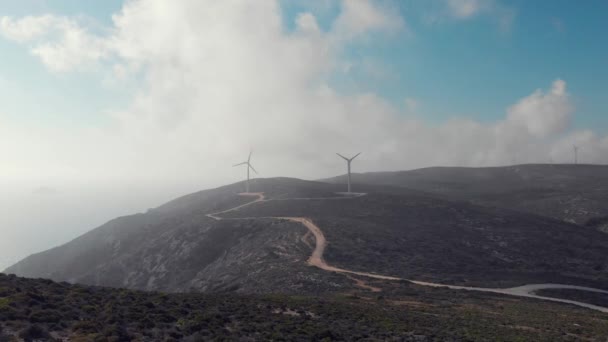 Silhuetas de moinho de vento incríveis operam no topo da colina verde — Vídeo de Stock