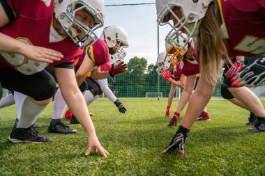 Yeşil çimüzerinde Amerikan futbolu oynayan kask takan sporcuların fotoğrafı