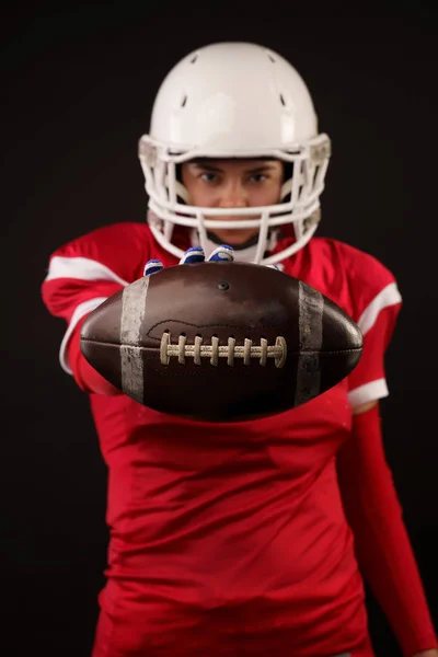 Picture of american woman football player in helmet with arm outstretched forward