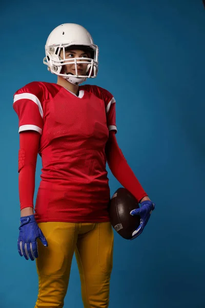 Kép amerikai női focista, fehér sisak, sportruházat és a labdát a kezében — Stock Fotó
