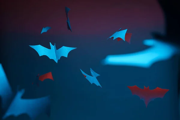 Foto de murciélagos de papel azul y rojo sobre fondo vacío de halloween . — Foto de Stock