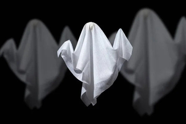검은 배경에 흰색 직물로 만든 세 할로윈 유령의 사진. — 스톡 사진