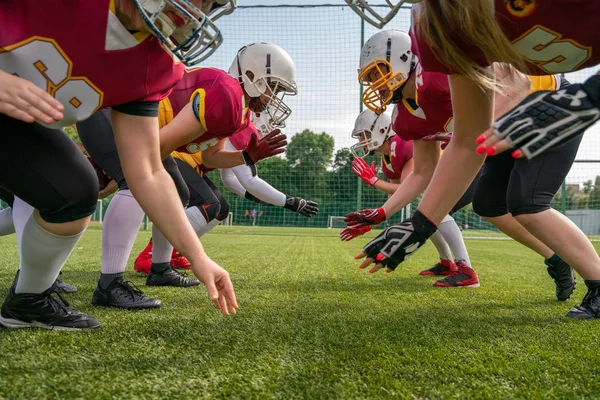 Foto de mujeres esportrivas con cascos jugando fútbol americano en césped verde —  Fotos de Stock