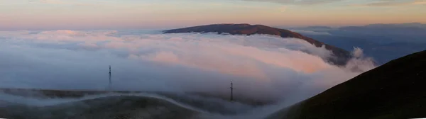 Sisli dağ alanının panoramik fotoğrafı, gün batımında elektrik santrali — Stok fotoğraf