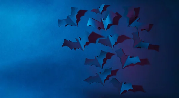 Imagen de Halloween de murciélagos de papel azul volando sobre fondo azul oscuro . —  Fotos de Stock