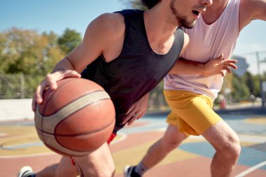 Yaz günü oyun alanında basketbol oynayan genç sporcuların fotoğrafı