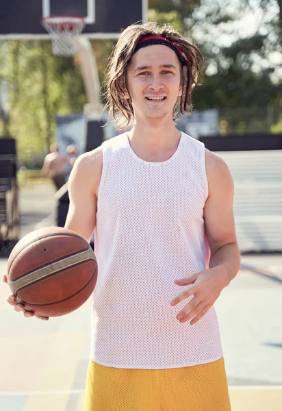 Foto van atleet in wit T-shirt met basketbal in de hand op speelplaats — Stockfoto