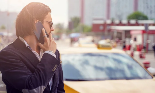 Foto di elegante bruna che parla al telefono vicino all'auto gialla in città — Foto Stock