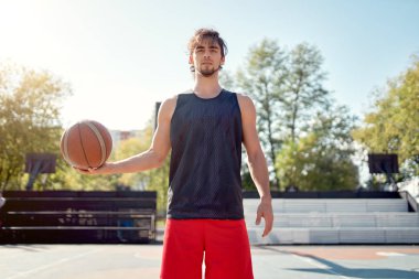 Spor sahasında elinde top ile mavi t-shirt sporcu adam Portresi .