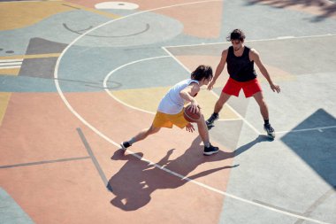 Sabah oyun alanında basketbol oynayan iki genç atletin en iyi görüntüsü.
