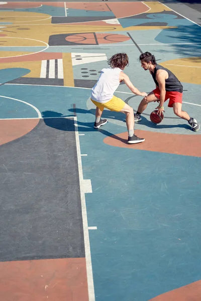 Bild von oben: Zwei Sportler spielen am Morgen Basketball auf einem Spielplatz. — Stockfoto