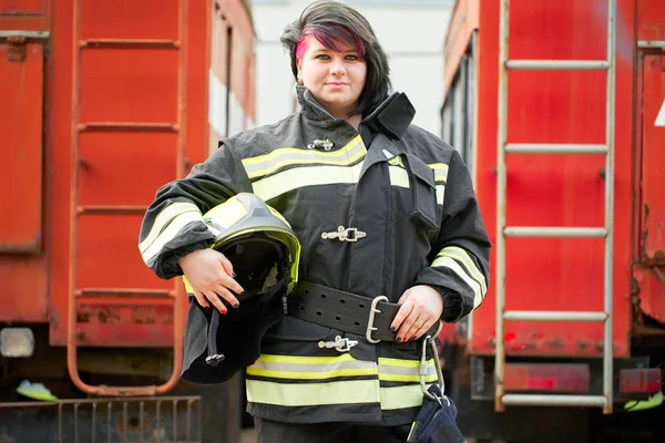 Foto des brünetten Feuerwehrmannes, der neben dem Feuerwehrauto steht — Stockfoto