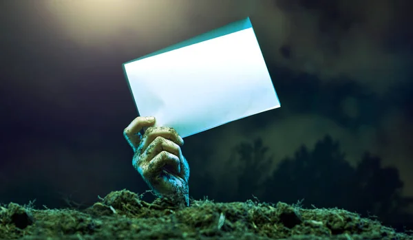 Image of zombie hands with empty sheet of paper sticking out — Stock Photo, Image