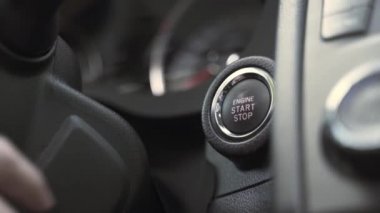 adam siyah direksiyon yakınında motor start düğmesine basar