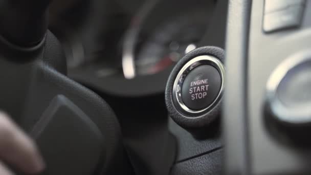 Άνθρωπος πιέζει το κουμπί εκκίνησης του κινητήρα κοντά στο μαύρο τιμόνι — Αρχείο Βίντεο