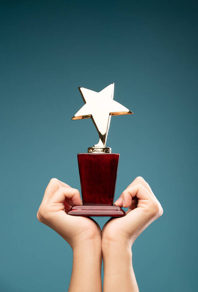 IImage of hands of man raising goblet with star