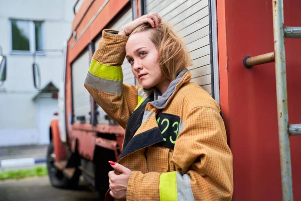Wizerunek strażaka Kobieta obok silników strażackie na ulicy. — Zdjęcie stockowe