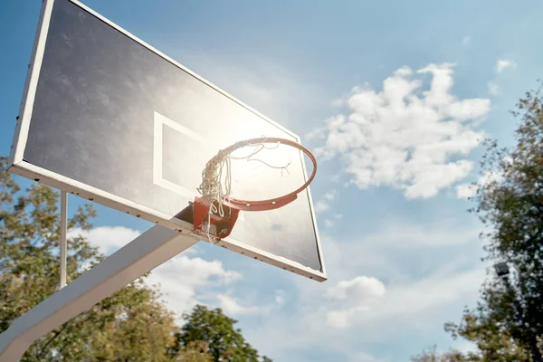 Изображение баскетбольного кольца против голубого облачного неба в летний день . — стоковое фото