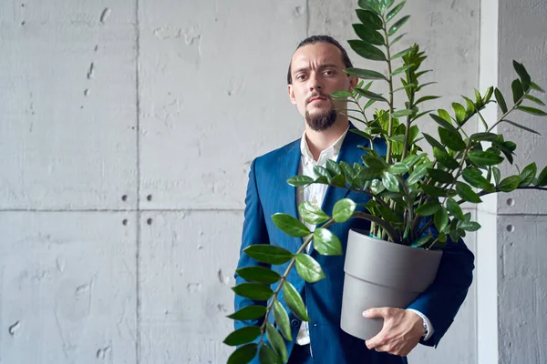 Foto do homem morena em terno de negócios com planta de sala na mão no fundo da parede de concreto cinza . — Fotografia de Stock