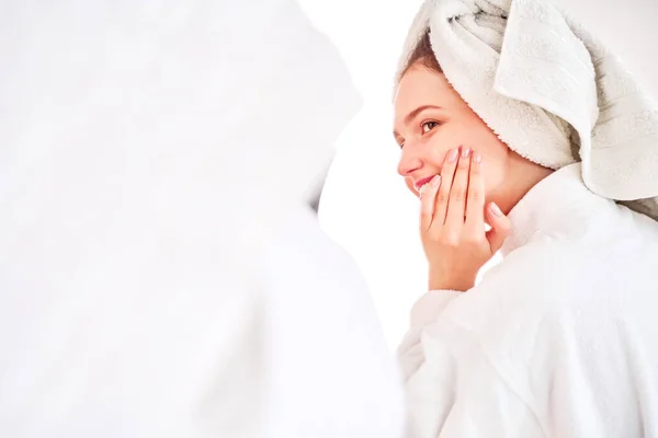 Foto lateral da mulher de casaco branco e com toalha na cabeça — Fotografia de Stock