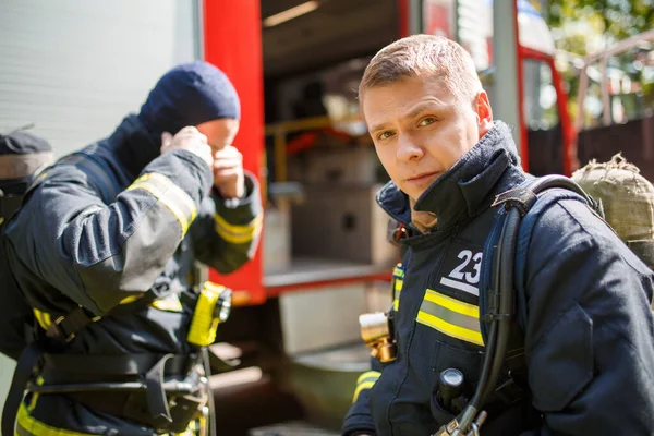 Zwei Männer stehen am Nachmittag in der Nähe eines Feuerwehrfahrzeugs, — Stockfoto