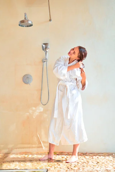 Foto de larga duración de la joven morena con el pelo mojado en albornoz blanco de pie en el baño — Foto de Stock