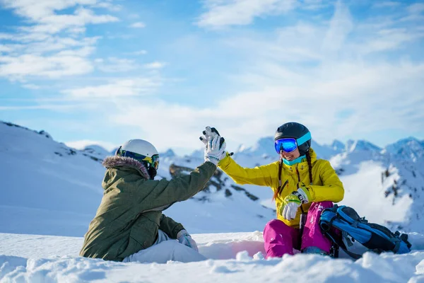 Foto de dois desportistas fazendo aperto de mão sentado no resort de neve . — Fotografia de Stock