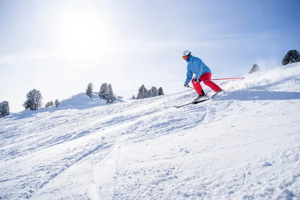 Sportowiec w kasku i masce narciarstwo na śnieżnym stoku . — Zdjęcie stockowe